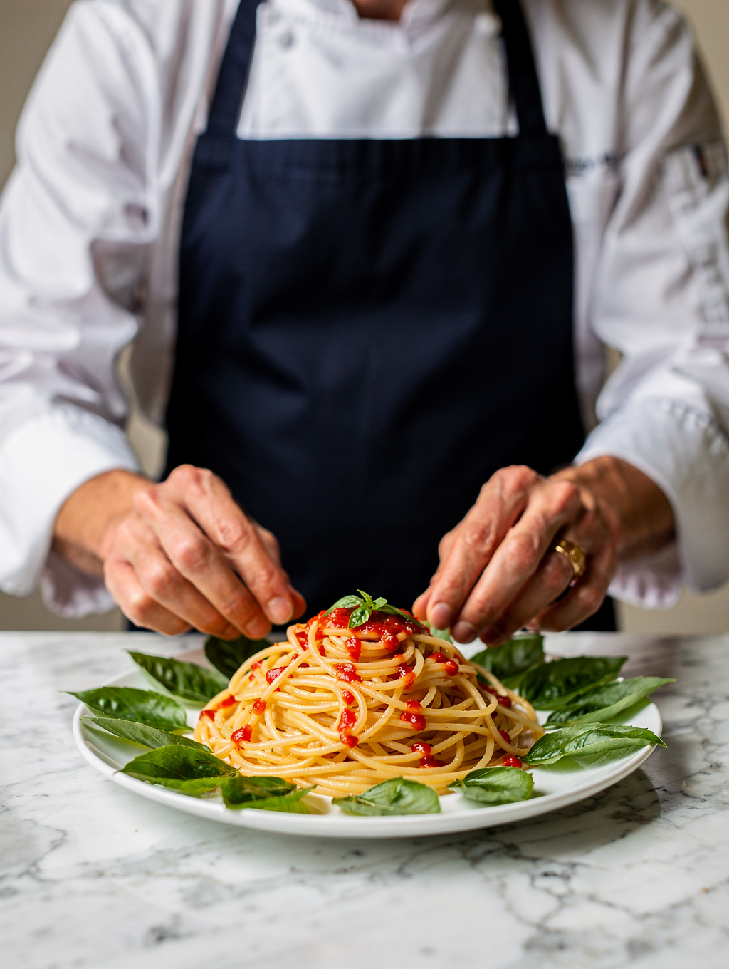 Chef plating a fresh seasonal Italian dish in our kitchen